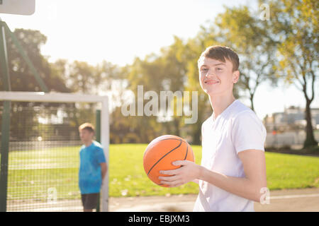Portrait of smiling young male basketball player sur un terrain de basket-ball Banque D'Images