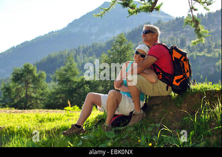 Couple resting in mountain meadow, France, Savoie Banque D'Images