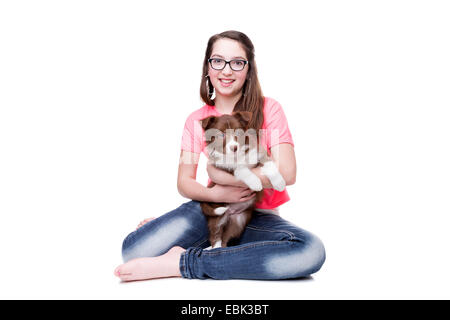 Fille avec un border collie puppy dog devant un fond blanc Banque D'Images