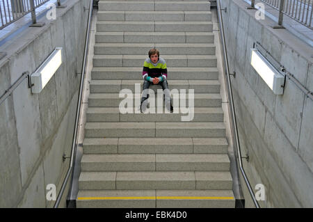 Lonesome 11-year-old boy sitting on stairs, Saxe, Dresde, Allemagne Banque D'Images