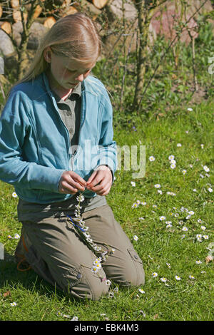 Ce faisant elle-même fille d'artisanat une ceinture de fleurs de marguerites anglais, Allemagne Banque D'Images