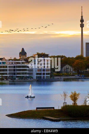 Bateau à voile sur le lac en face de la Phoenix Hoerder Burg et la tour de télévision Florian au coucher du soleil, de l'Allemagne, en Rhénanie du Nord-Westphalie, Ruhr, Dortmund Banque D'Images