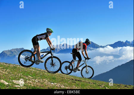 Deux mountain biker on mountain meadow appréciant les paysages de montagne, France, Savoie, La Plagne Banque D'Images