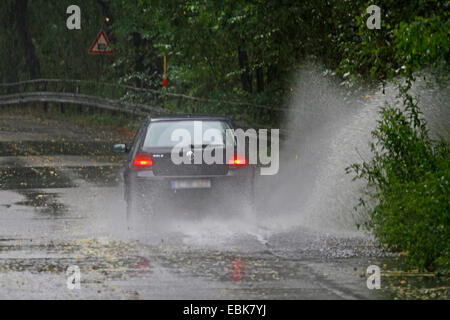 Une voiture passe à travers la route inondée, Allemagne Banque D'Images