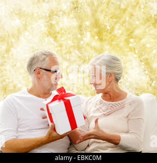 Happy senior couple with gift box à la maison Banque D'Images