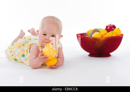 Bébé de 10 mois avec le panier de fruits et des fruits dans ses mains Banque D'Images