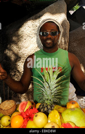 Dark-skinned man selling exotical fruits, Seychelles, Digue Island Banque D'Images