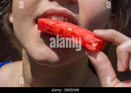 Jeune femme sur le point de mordre dans une tranche de melon d'eau Banque D'Images