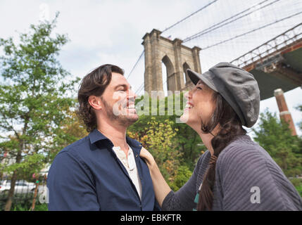USA, l'État de New York, New York City, Brooklyn, Happy couple standing contre Pont de Brooklyn Banque D'Images
