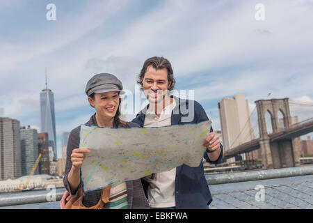 USA, l'État de New York, New York City, Brooklyn, heureux couple reading map Banque D'Images