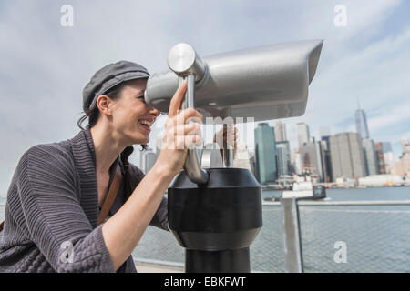 USA, l'État de New York, New York City, Brooklyn, Femme regardant à travers des jumelles Banque D'Images