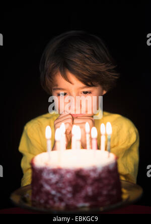 Portrait of boy (6-7) pensée de souhaits d'anniversaire, gâteau d'anniversaire de Banque D'Images
