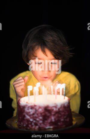 Portrait of boy (6-7) blowing out birthday candles Banque D'Images