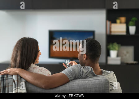 Couple assis dans le salon et regarder la télévision Banque D'Images