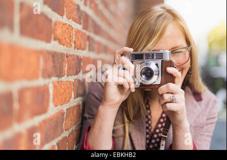 Woman photographing with vintage camera Banque D'Images