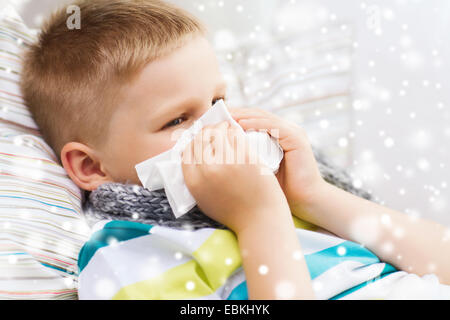 Mauvais Garçon blowing nose avec les tissus à la maison Banque D'Images