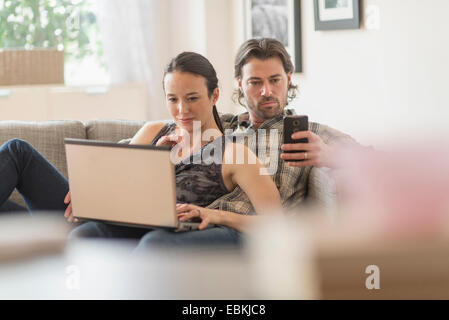 Couple on sofa, portrait et l'homme mobile phone Banque D'Images