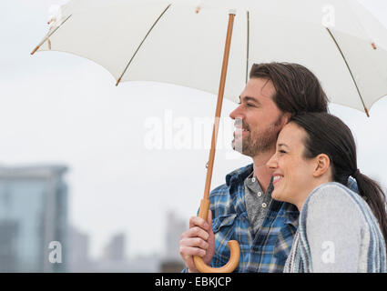 Vue latérale du couple under umbrella Banque D'Images