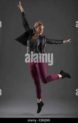 Studio shot of woman with arms raised Banque D'Images