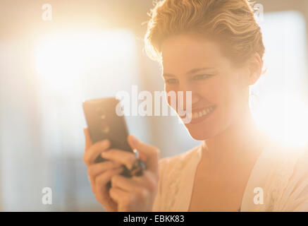 Smiling young woman using mobile phone Banque D'Images