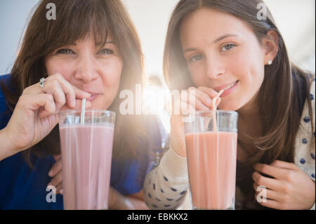 Portrait de Mère et fille (14-15) boire des milkshakes Banque D'Images