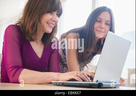 Teenage girl (14-15) using laptop avec sa maman à la maison Banque D'Images