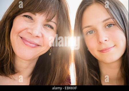 Portrait of smiling mom and daughter (14-15) à l'intérieur