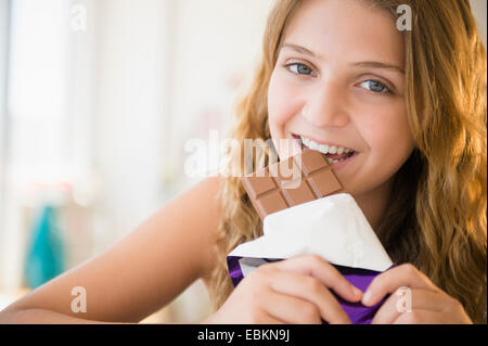 Girl (12-13) manger du chocolat Banque D'Images