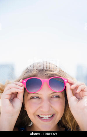 Girl (12-13) avec des lunettes de soleil rose Banque D'Images