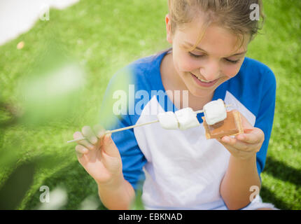 Girl (12-13) using les guimauves Banque D'Images