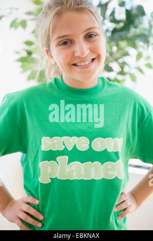 Portrait of smiling teenage girl (12-13) wearing green t-shirt Banque D'Images