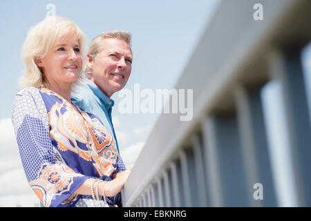 Portrait de couple à balustrade, looking at view Banque D'Images