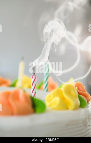 Studio shot of soufflé les bougies sur le gâteau Banque D'Images