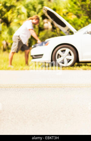 USA, Floride, Tequesta, jeune homme à la recherche de moteur de voiture Banque D'Images