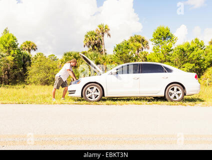 USA, Floride, Tequesta, jeune homme à la recherche de moteur de voiture Banque D'Images