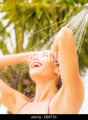 Woman taking douche extérieur Banque D'Images