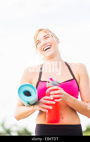 Portrait of smiling woman drinking water Banque D'Images