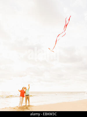 USA, Floride, Jupiter, Couple flying kite on beach Banque D'Images