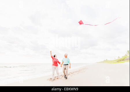 USA, Floride, Jupiter, Couple flying kite on beach Banque D'Images