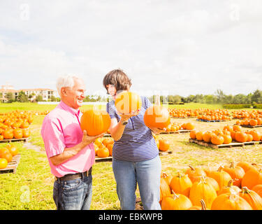 USA, Floride, Jupiter, Couple talking et holding pumpkins Banque D'Images