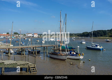 Bateaux amarrés sur la rivière Deben à Woodbridge avec moulin à marée à distance Banque D'Images