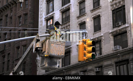 Manhattan New York USA Novembre 2014 - Nettoyage Workman feux de circulation à l'aide d'un pinceau sur un poteau en plein centre de New York Banque D'Images