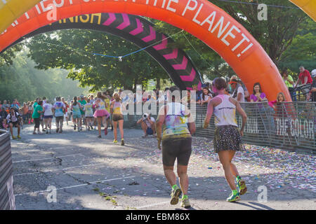 Heureux coureurs éclaboussés de teintures colorées la ligne d'arrivée approche dans l'Asheville 5K Color Run Banque D'Images