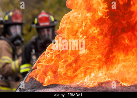 Les pompiers éteindre les feux d'une voiture Banque D'Images