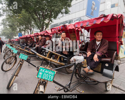 Les pousse-pousse garé côte à côte dans les rues de Beijing, Chine Banque D'Images