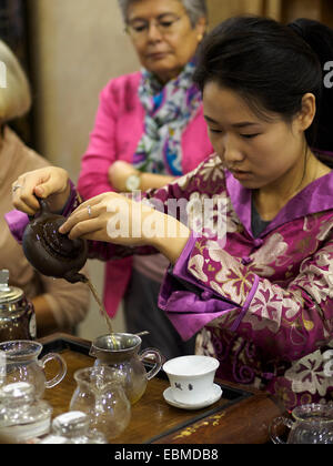 Young woman pouring tea au cours d'une cérémonie de thé chinois traditionnel Banque D'Images