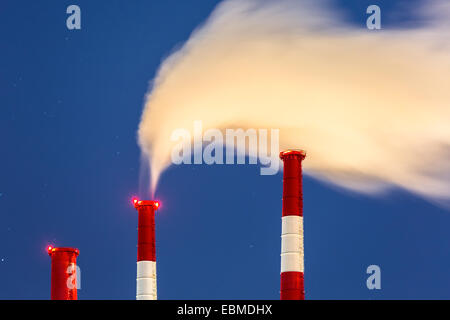 Les cheminées de la centrale électrique avec un nuage de vapeur soufflé par le vent sur une froide nuit d'hiver étoilée Banque D'Images