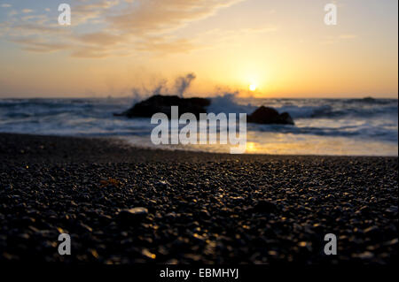 Résumé de l'océan trouble rive et coucher de soleil romantique. Se concentrer sur les cailloux lumineux. Profondeur de champ. Lanzarote, Canary Island Banque D'Images