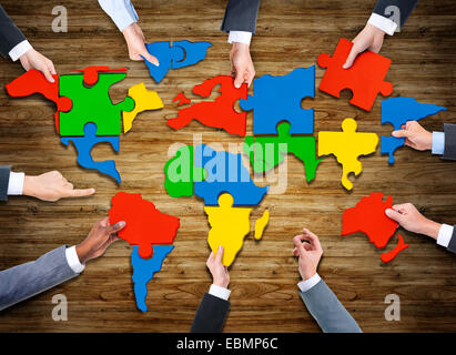 Vue aérienne de personnes formant la carte du monde des pièces de puzzle Banque D'Images