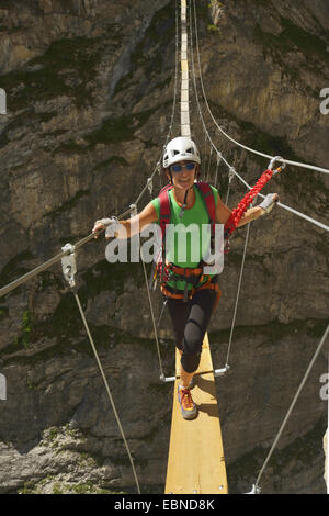 Female hiker traversant un canyon sur petit pont, France, Savoie, Roc de Toviere Banque D'Images